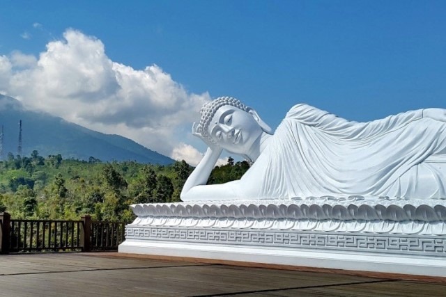 Patung Budha tidur dalam ukuran besar yang tampil megah dengan warna yang putih bersih. Posisinya menggambarkan Budha yang sedang tidur dengan memangkukan kepala di satu tangannya.